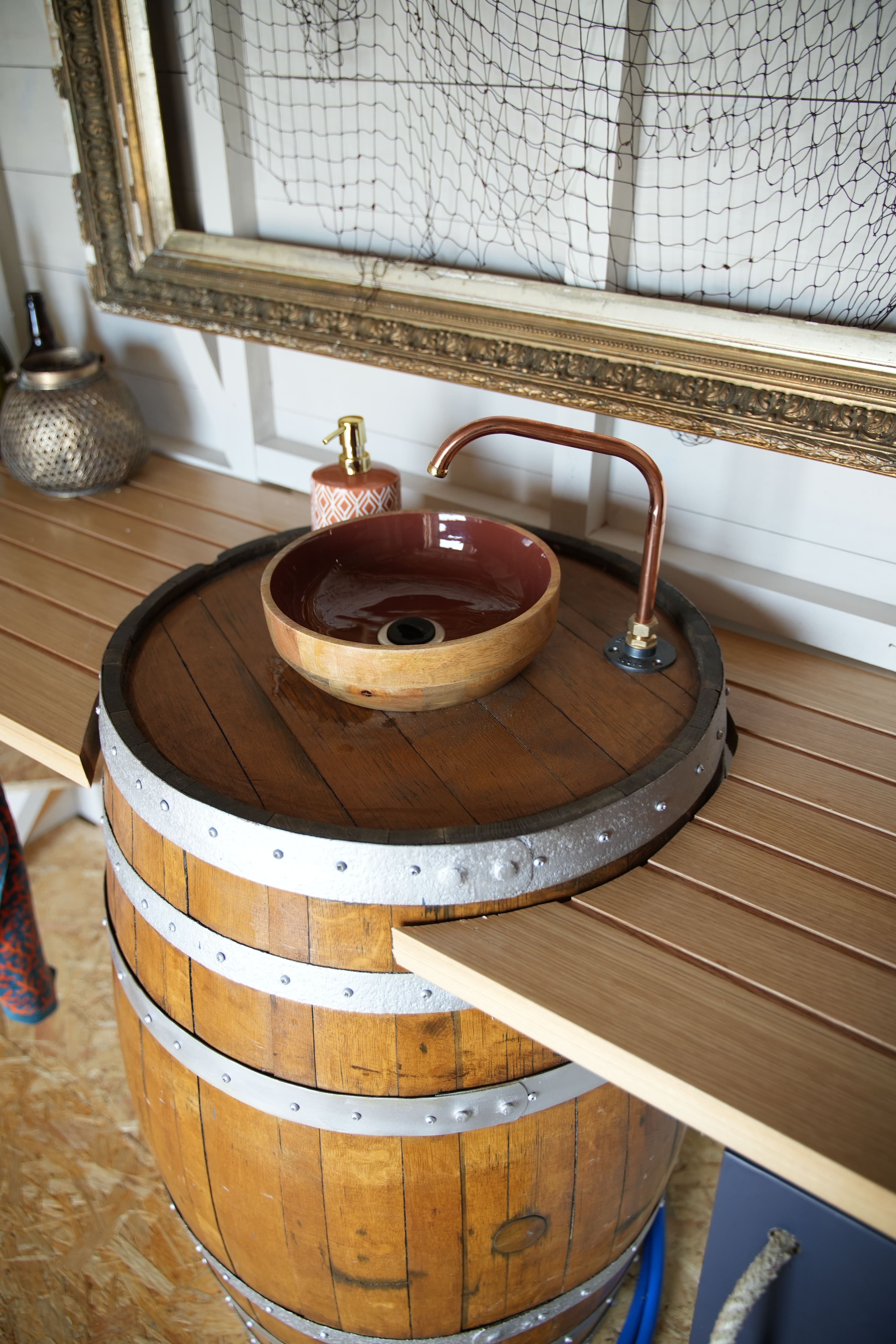 A close up of a barrel-turned-sink complete with copper tap.
