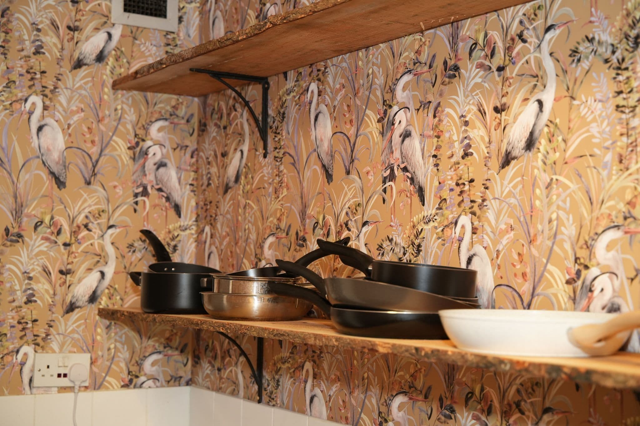 The original kitchen became a pantry with live-edge wood shelving for pots and pans